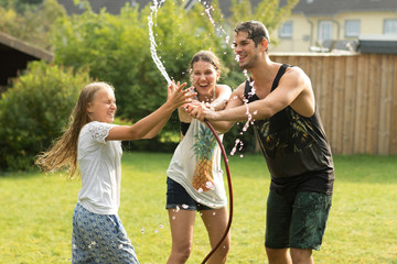junge Familie spielt mit Wasser