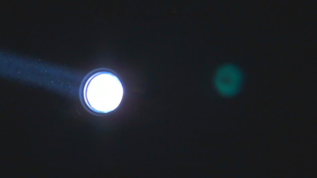 Spotlight Moves in the Dark 1 / Bright floodlight rotates. From searchlight comes a ray of light
