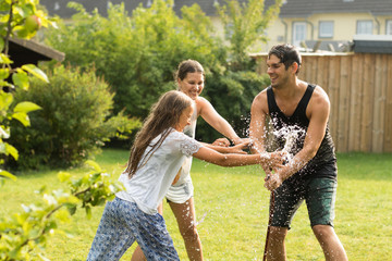 junge Familie spielt mit Wasser