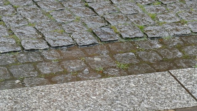 Gepflasterte Rinne bei Regen