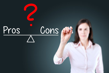 Young business woman writing pros and cons compare on balance bar. Blue background.
