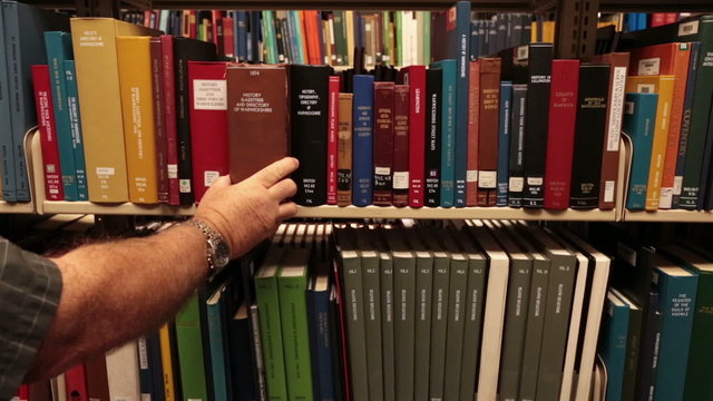 Man removed book from shelf genealogy library HD 8748