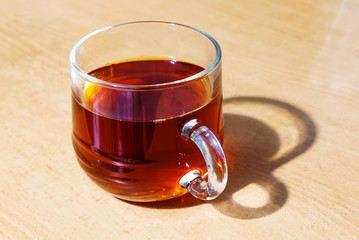 Glass cup of tea on a table made of wood