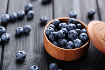Tasty blueberries in bowl on a black wooden table