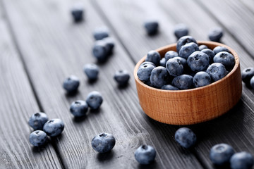 Tasty blueberries in bowl on a black wooden table