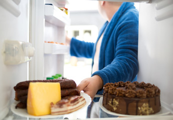Overweight  guy take sausage and cheese from fridge