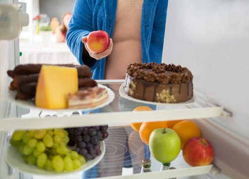 Man on diet take healthy apple instead of hard food