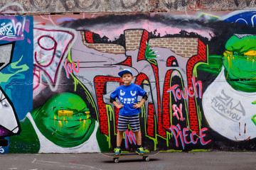 Confident little boy posing on his skateboard