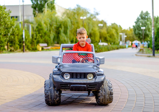 Cute Little Boy Driving A Toy Truck