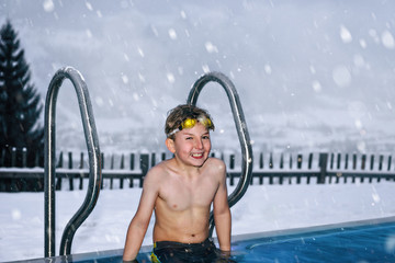 the boy in the wintertime in pool with outdoor terrace covered i