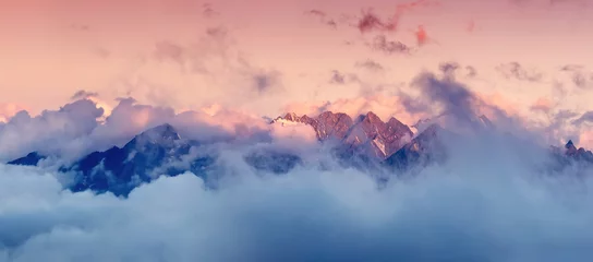 Tuinposter Hoge bergketen in de wolken tijdens zonsopgang. Prachtig panoramisch landschap © biletskiyevgeniy.com