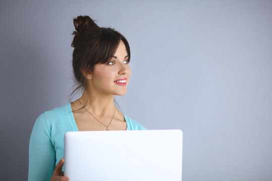 Happy young woman using her laptop