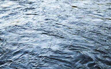 Fast river water background with waves and ripples