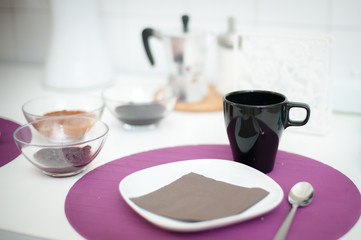 Breakfast set table, focus on black cup