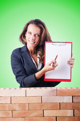 Woman builder and brick wall