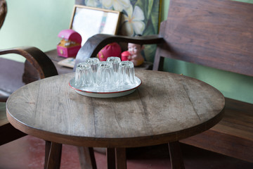 Glasses on white tray put up side down on wood table with na