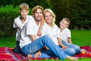 Happy family lying on the grass in summer. Picnic concept