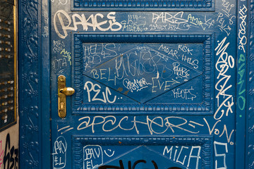 Puerta azul con pintadas.
