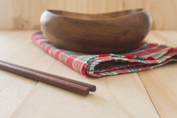 Close up chopstick with empty bowl on wood table background