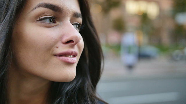 5 in 1 video! The young woman turn head and smile in the center city by building background. Camera roundabouts view. Slow motion capture