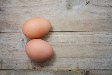 two raw eggs on a wood table