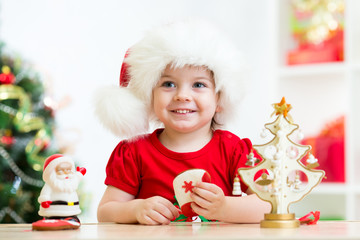 Fototapety  Mała dziewczynka ubrana w świąteczną czerwoną czapkę Mikołaja z Bożym Narodzeniem