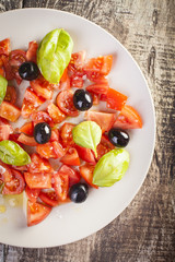 Salad dish with tomato, olives and basil