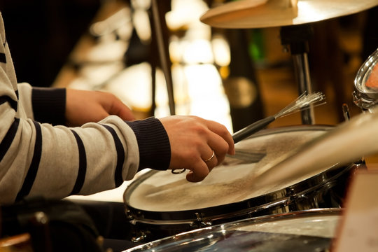 Hands of a man playing a drum set
