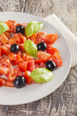 Salad dish with tomato, olives and basil
