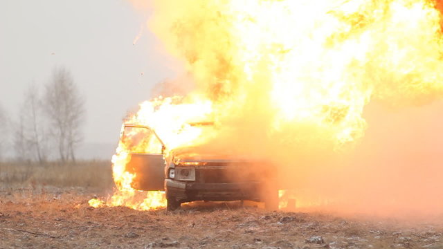Car explosion on an empty field, slow-mo, front view