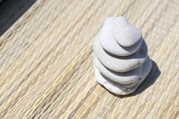 Fototapeta na wymiar Pebble stones on the straw mat.