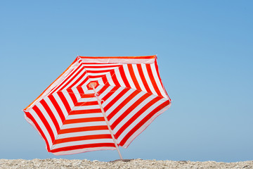 Striped beach umbrella on the beach.

