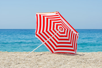 Striped beach umbrella on the beach.     © Evgeny Korshenkov