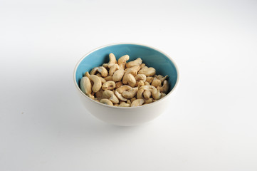 Cashew nuts on bowl on a white background