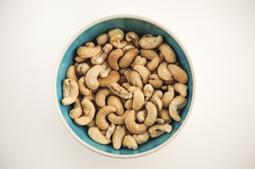 Cashew nuts on bowl on a white background