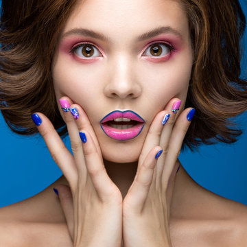 Beautiful model girl with bright makeup and colored  nail polish. Beauty face. Short colorful nails