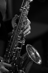Obraz premium Hands girl playing the saxophone in black and white