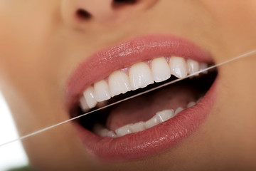 Woman using dental floss.