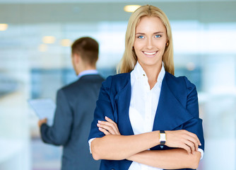 Portrait of young businesswoman in office with colleagues in the