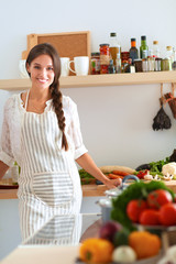 Young woman standing near desk in the kitchen