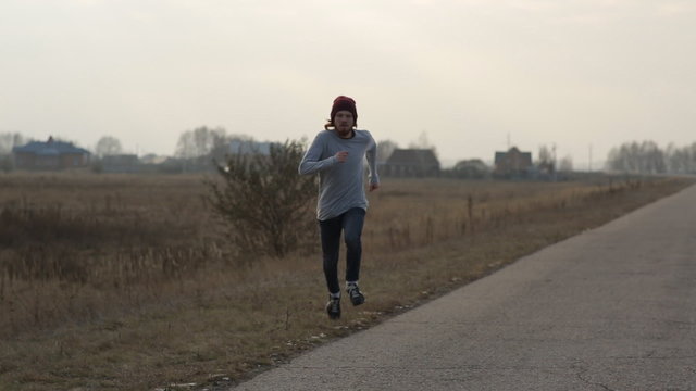 Guy runs out onto the road and keeps running. Steadicam shot