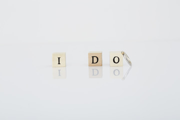Letter tiles say 'I Do' next to wedding ring