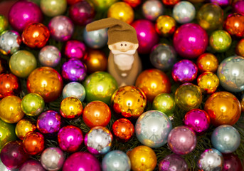 vintage Santa Claus figure between many colorful christmas baubles, christmas decoration