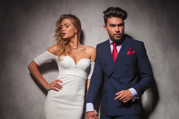 hot elegant couple holding hands and posing in studio