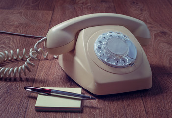 Retro telephone on wooden table in front gradient background