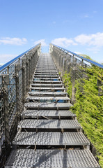 Fototapeta premium Stairway to heaven - steel staircase going up to a blue sky with