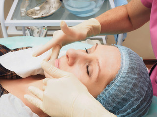 Obraz na płótnie Canvas Cosmetology procedure rejuvenation, revitalization, skin nutrition . Doctor making mask of beauty cream.