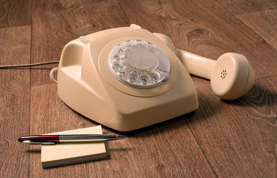 Retro telephone on wooden table in front gradient background