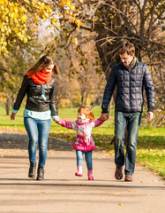 Fototapeta premium Happy young family walks in the park