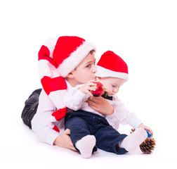 Boys brothers in santa's hats hugging